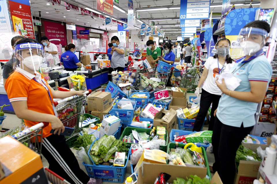 Thu ngân không kịp tính tiền, khiến dồn ứ hàng hóa trong siêu thị. (Ảnh: Thanh Vũ/TTXVN)