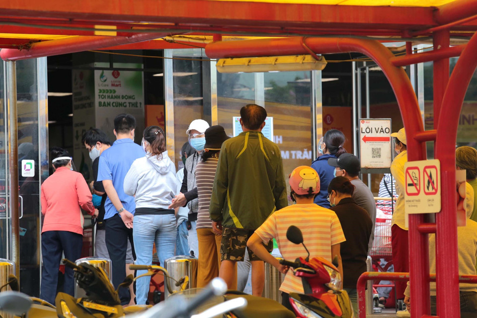 Người tiêu dùng xếp hàng mua sắm hàng hóa tại siêu thị Emart Gò Vấp. (Ảnh: Mạnh Linh/TTXVN)