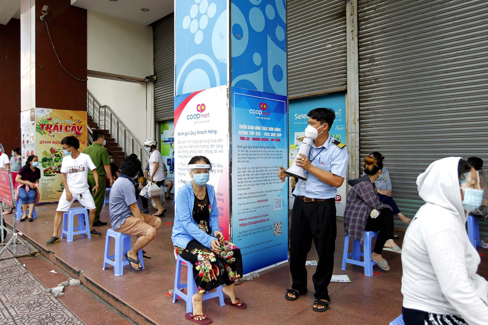 Người dân xếp hàng chờ đến lượt vào mua sắm tại siêu thị Co.op mart Nhiêu Lộc-Thị Nghè. (Ảnh: Thanh Vũ/TTXVN)