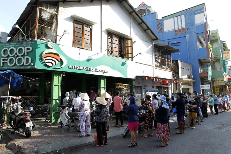 Người tiêu dùng ùn ùn xếp hàng mua sắm tại cửa hàng Co.op Food trên đường Tô Hiến Thành (Quận 10). (Ảnh: Thanh Vũ/TTXVN)