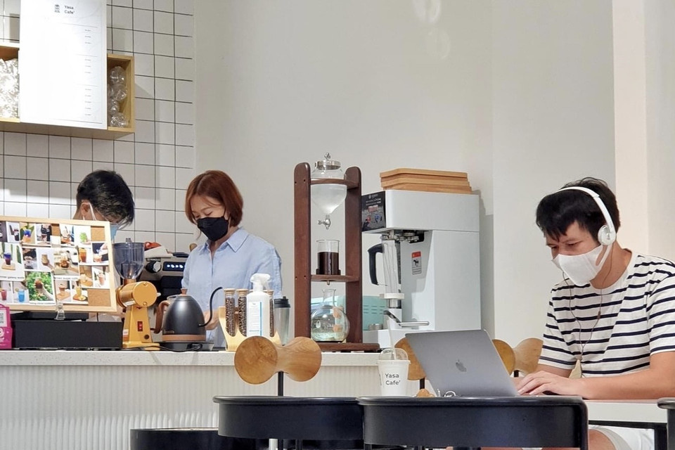 Nhân viên và thực khách tại một quán càphê tại Quận 1 thực hiện đeo khẩu trang phòng dịch. (Ảnh: Hồng Giang/TTXVN).