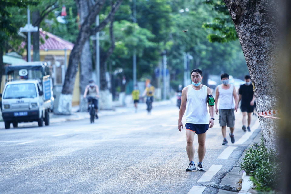 Một số người dân đi tập thể dục vẫn đeo khẩu trang không đúng cách trong lúc tình hình dịch bệnh vẫn còn phức tạp (ảnh chụp lúc 5h55p ngày 13/7 trên đường Nguyễn Du). (Ảnh: Hoàng Hiếu/TTXVN)