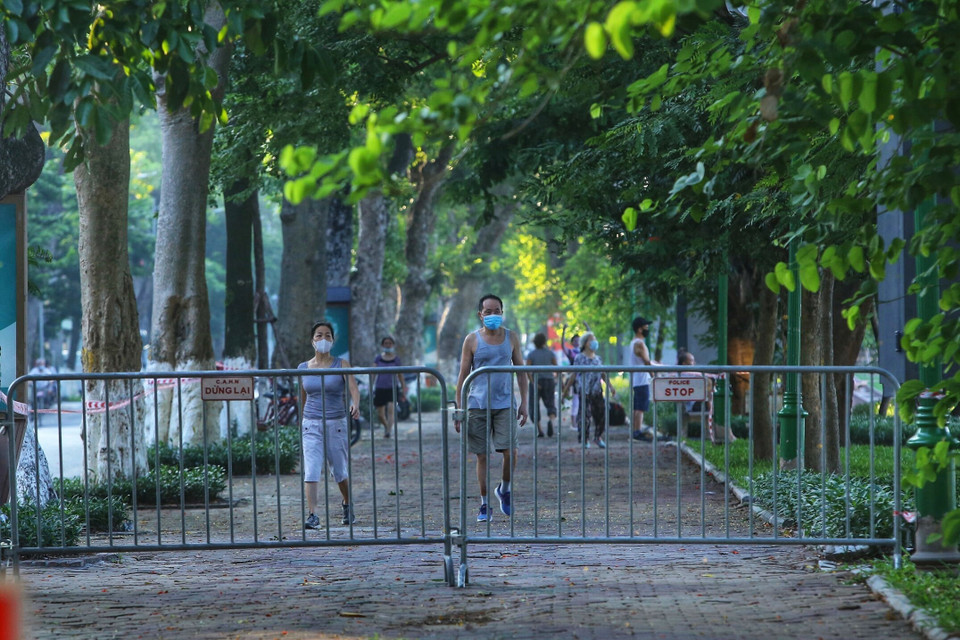 Nhiều người dân vẫn tập thể dục tại khu vực hồ Thiền Quang dù đã được lực lượng chức năng căng dây, cắm biển cấm (ảnh chụp lúc 5h50 ngày 13/7). (Ảnh: Hoàng Hiếu/TTXVN)