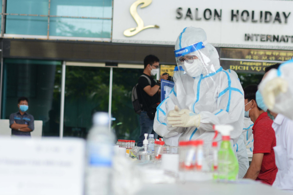 Nhân viên y tế thay gang tay sau mỗi lần lấy mẫu xét nghiệm. (Ảnh: Văn Dũng/TTXVN)