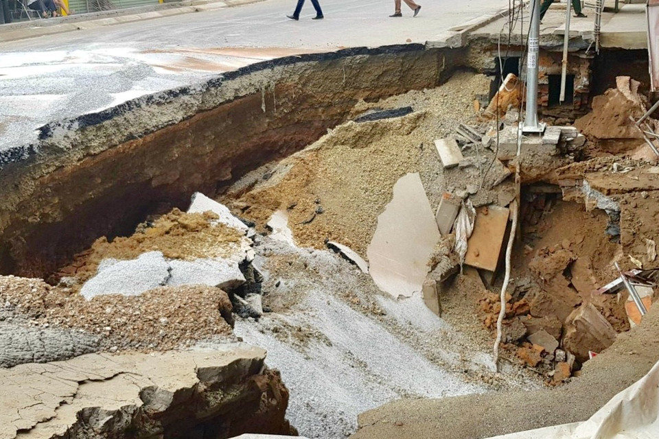 Sự cố sụt lún đất tạo thành hố sâu có chiều dài khoảng 15m và chiều rộng từ phía nhà dân ra mặt đường khoảng 7m. (Ảnh: Nguyễn Thắng/TTXVN)