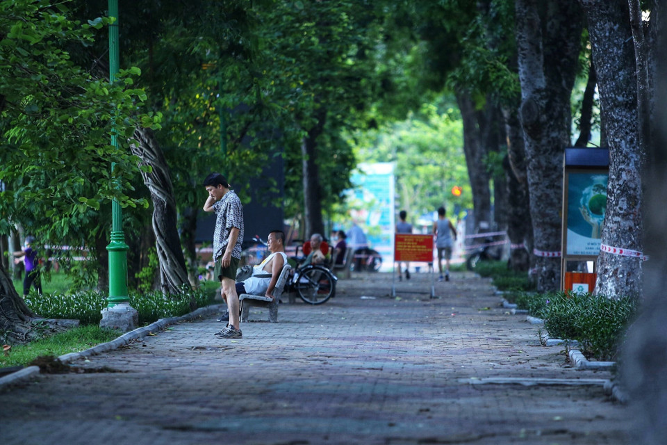 Một số người dân vẫn không đeo khẩu trang, tập thể dục khu vực ven hồ ven hồ Thiền Quang (dù lực lượng Công an phường Nguyễn Du đã căng dây, để biển báo yêu cầu không vi phạm. Ảnh chụp 5h50 ngày 13/7/2021). (Ảnh: Hoàng Hiếu/TTXVN)