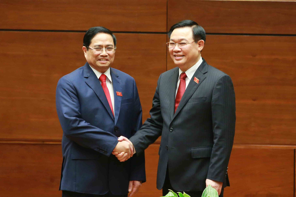 Chủ tịch Quốc hội Vương Đình Huệ chúc mừng Thủ tướng Phạm Minh Chính. (Ảnh: Phương Hoa/TTXVN)