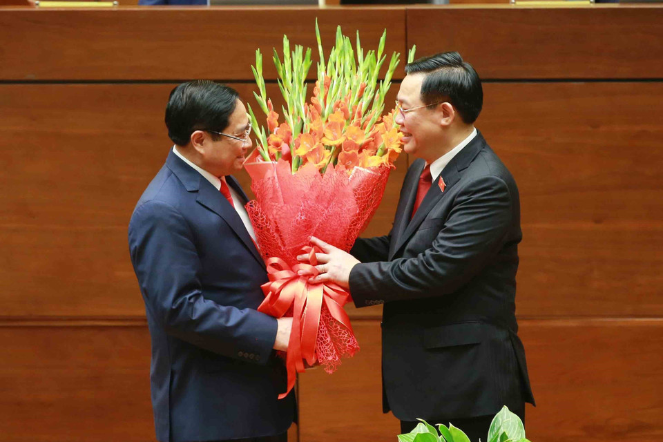 Chủ tịch Quốc hội Vương Đình Huệ tặng hoa chúc mừng Thủ tướng Phạm Minh Chính. (Ảnh: Phương Hoa/TTXVN)