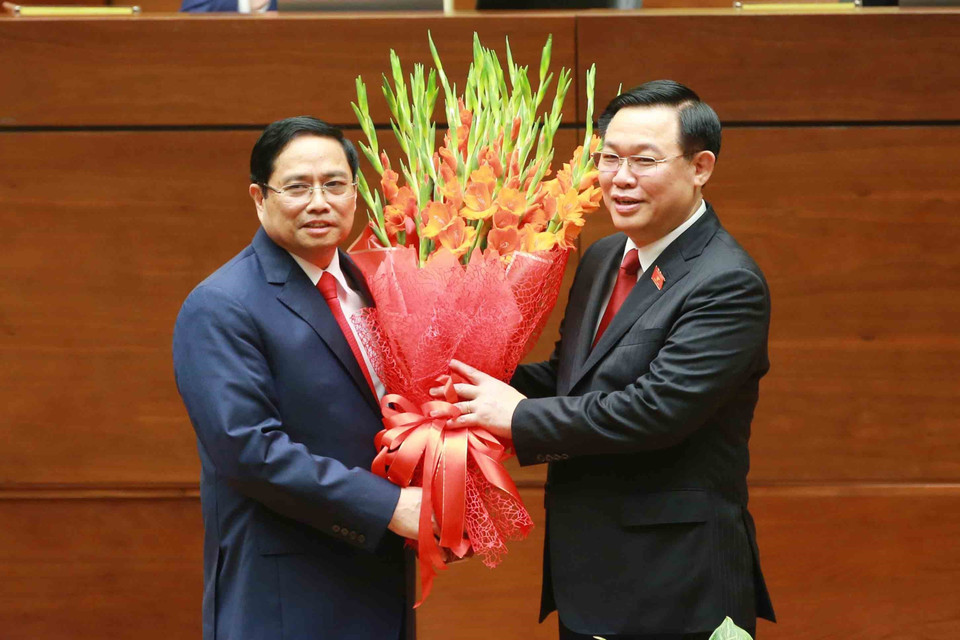 Chủ tịch Quốc hội Vương Đình Huệ tặng hoa chúc mừng Thủ tướng Phạm Minh Chính. (Ảnh: Phương Hoa/TTXVN)