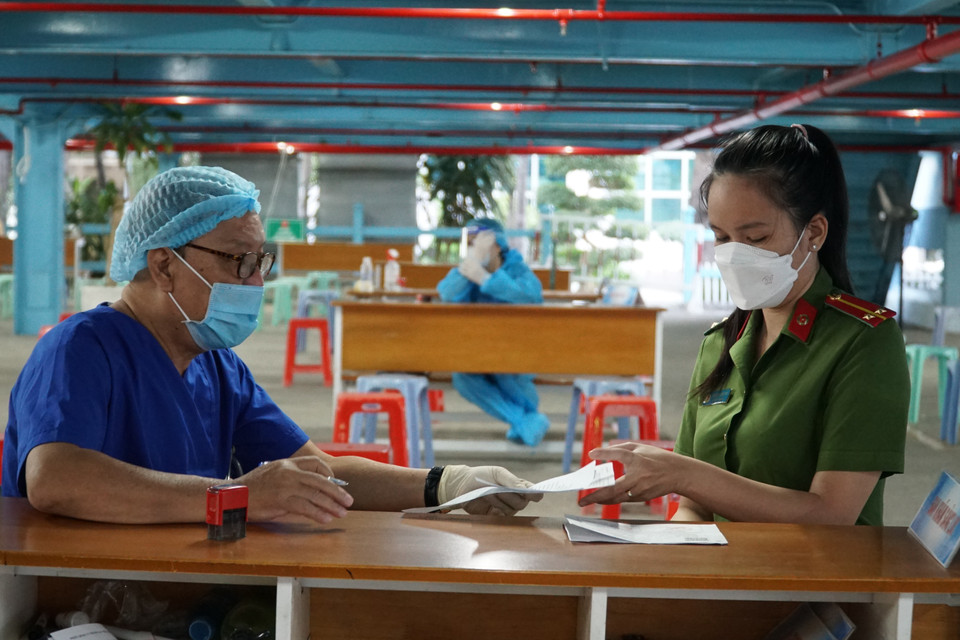 Nhân viên y tế tư vấn cho lực lượng công an trước khi tiêm vaccine. (Ảnh: Thu Hương/TTXVN)