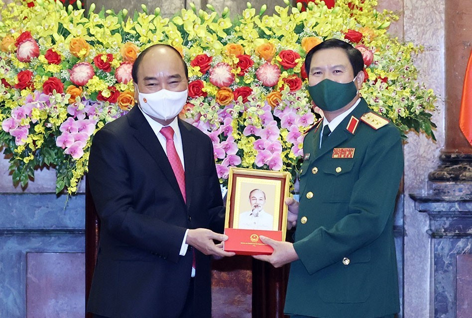 Chủ tịch nước Nguyễn Xuân Phúc tặng chân dung Chủ tịch Hồ Chí Minh cho Thượng tướng Nguyễn Tân Cương. (Ảnh: Thống Nhất/TTXVN)