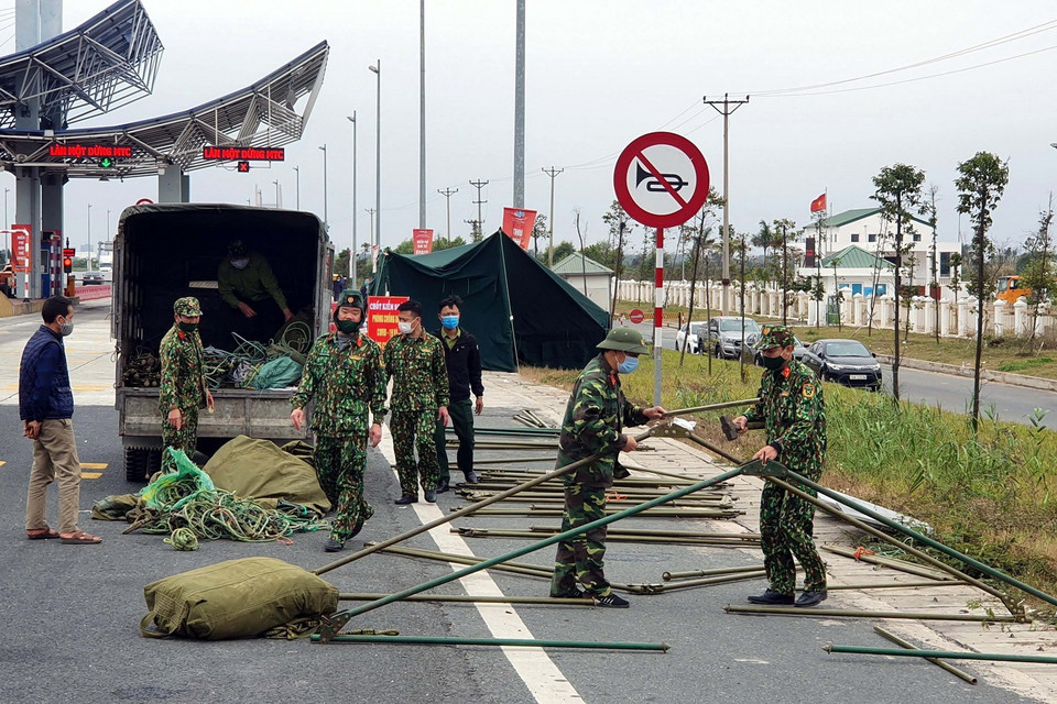  Lực lượng chức năng dựng lán chuẩn bị cho công tác phòng chống COVID-19 tại chốt trạm cầu Bạch Đằng, thị xã Quảng Yên. (Ảnh: TTXVN)
