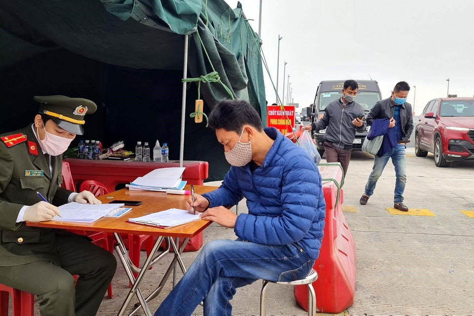  Lực lượng chức năng làm nhiệm vụ hướng dẫn, phân luồng giao thông, khai báo y tế tại chốt trạm cầu Bạch Đằng, thị xã Quảng Yên. (Ảnh: TTXVN)