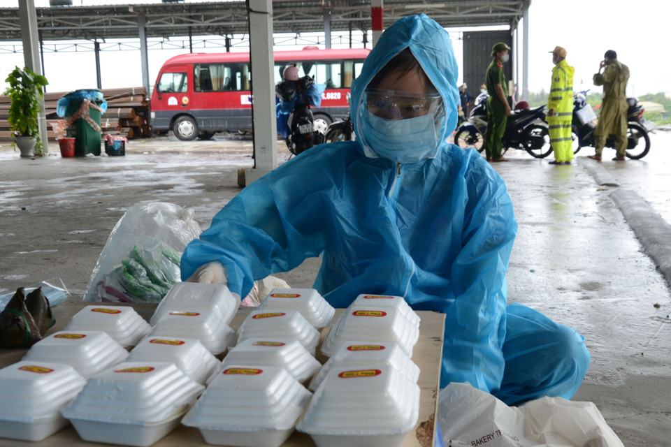 Tình nguyện viên cẩn thận sắp xếp những phần ăn nóng hổi để đón đoàn người về quê. (Ảnh: Quốc Dũng/TTXVN)