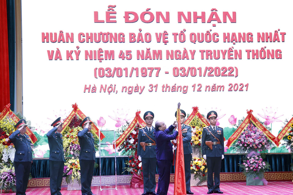 Chủ tịch nước Nguyễn Xuân Phúc gắn Huân chương Bảo vệ Tổ quốc hạng Nhất lên lá cờ truyền thống của Học viện Quốc phòng. 