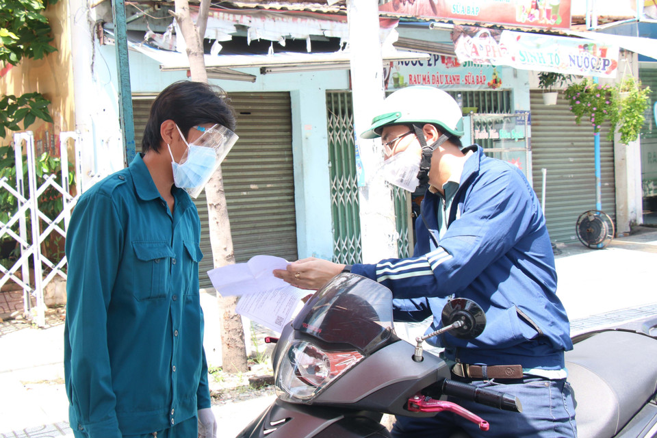 Lực lượng công an tại chốt kiểm soát cầu Chợ Cầu (Gò Vấp) kiểm tra giấy tờ người đi đường. (Ảnh: Tiến Lực/TTXVN)