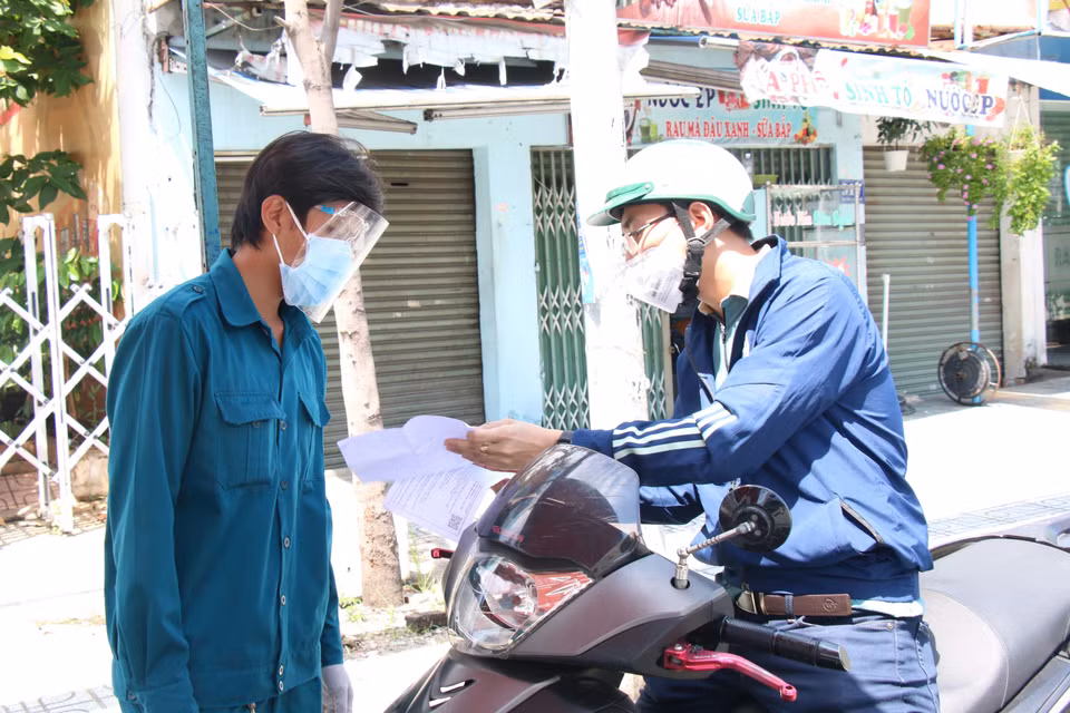 Lực lượng công an tại chốt kiểm soát cầu Chợ Cầu (Gò Vấp) kiểm tra giấy tờ người đi đường. (Ảnh: Tiến Lực/TTXVN)