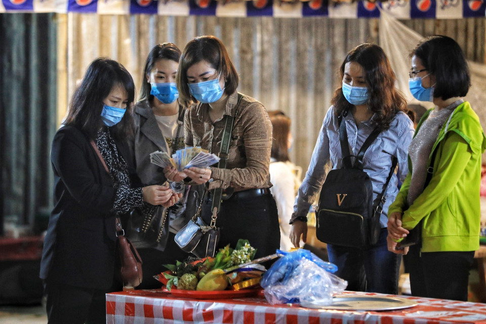  Những du khách đầu tiên đến Đền Trình và chuẩn bị đồ lễ trong ngày chùa Hương mở cửa trở lại. (Ảnh: Thành Đạt/TTXVN)