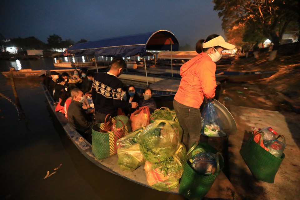 Chuyến đò đầu tiên chở du khách cùng một số hàng hóa của chủ đò cập bến Đền Trình từ rất sớm. (Ảnh: Thành Đạt/TTXVN)
