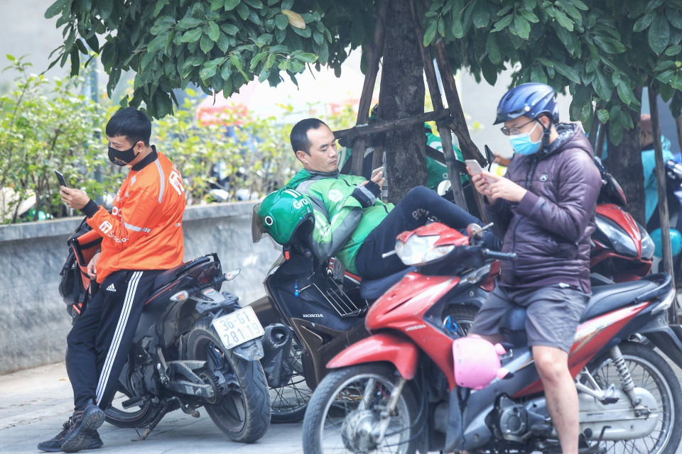 Một lái xe công nghệ không đeo khẩu trang trong lúc chờ khách. (Ảnh: Tuấn Anh/TTXVN)