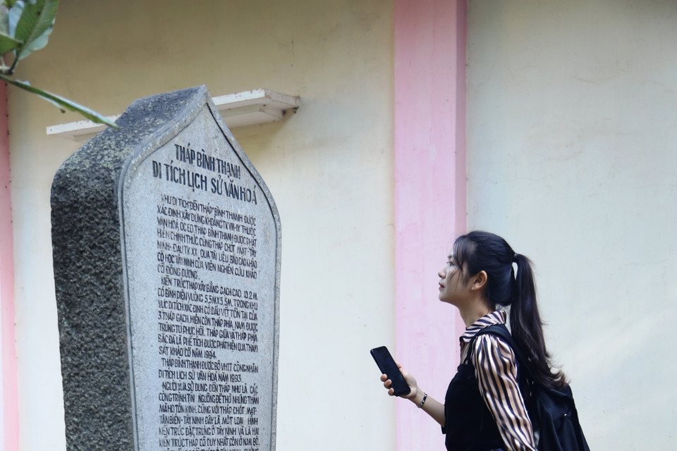 Khách tham quan tìm hiểu về quá trình hình thành tháp cổ Bình Thạnh. (Ảnh: Thanh Tân/TTXVN)