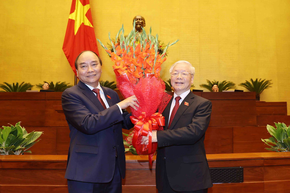 Chủ tịch nước Nguyễn Xuân Phúc tặng hoa đồng chí Nguyễn Phú Trọng, nguyên Chủ tịch nước. (Ảnh: Trí Dũng/TTXVN)