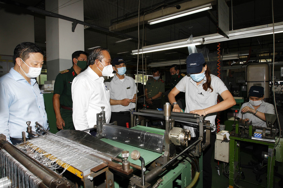 Phó Thủ tướng thường trực Chính phủ Trương Hòa Bình kiểm tra phòng, chống dịch bệnh tại Công ty trách nhiệm hữu hạn Kim may Organ. (Ảnh: Thanh Vũ/TTXVN)