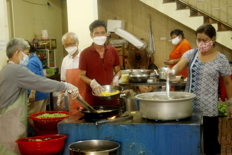 Cán bộ, nhân viên Ủy ban Nhân dân phường Thống Nhất, thành phố Buôn Ma Thuột nấu cơm để phát cho người dân về quê. (Ảnh: TTXVN phát)