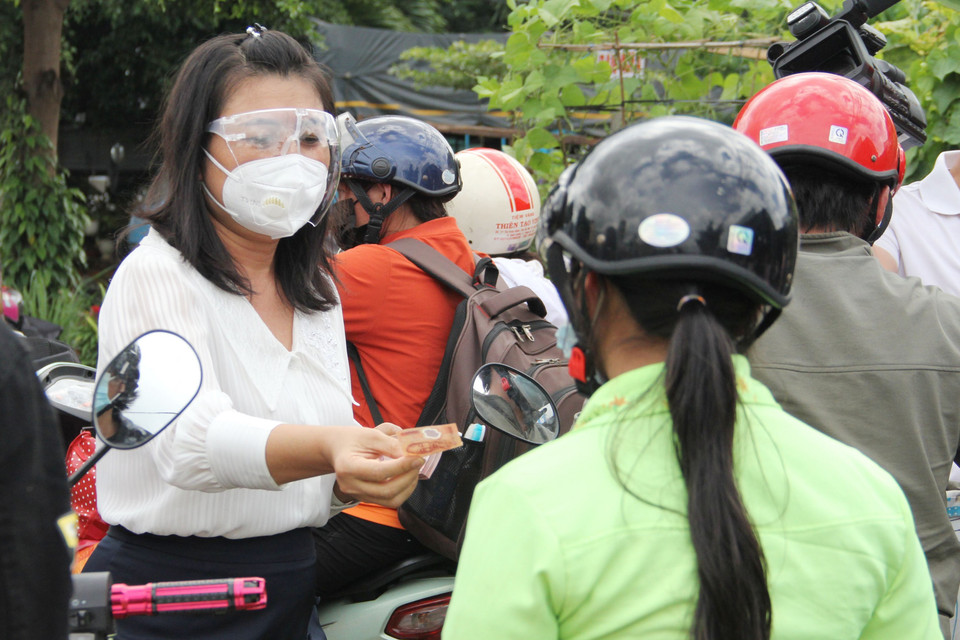 Phó Chủ tịch UBND tỉnh Đắk Lắk H’Yim Kđoh hỗ trợ tiền xăng cho người dân về quê. (Ảnh: TTXVN phát)