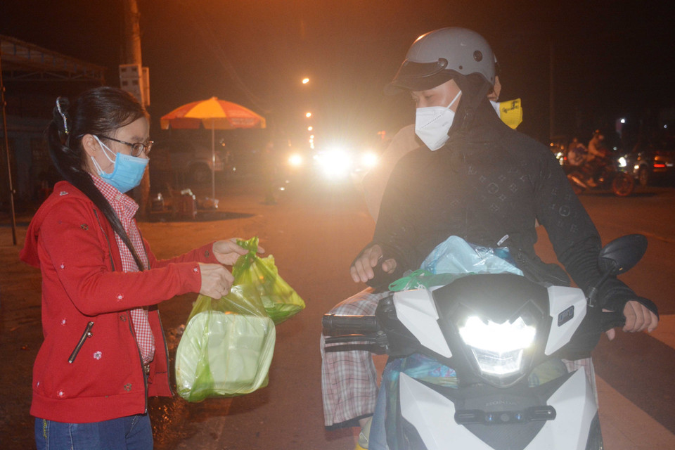 Người dân về quê đi ngang tỉnh Đắk Lắk được hỗ trợ các phần cơm và nước uống. (Ảnh: Hoài Thu/TTXVN)