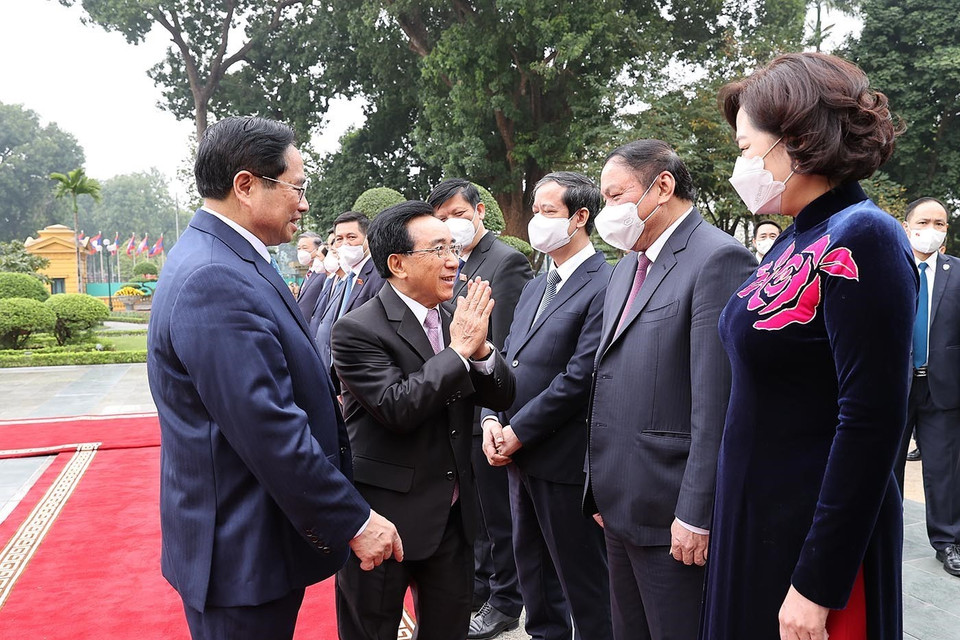 Thủ tướng Phạm Minh Chính giới thiệu với Thủ tướng Lào Phankham Viphavanh thành viên đoàn Việt Nam dự lễ đón. (Ảnh: Dương Giang/TXVN)
