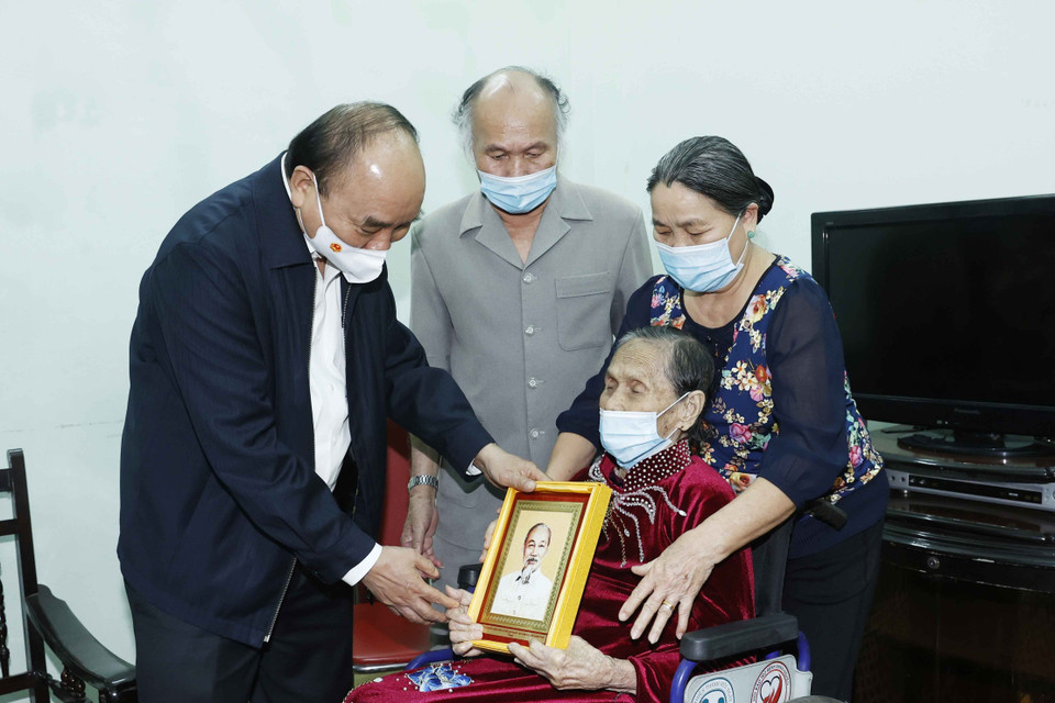 Chủ tịch nước Nguyễn Xuân Phúc tặng bức ảnh chân dung Chủ tịch Hồ Chí Minh cho Mẹ Việt Nam Anh hùng Nguyễn Thị Cang. (Ảnh: Thống Nhất/TTXVN)