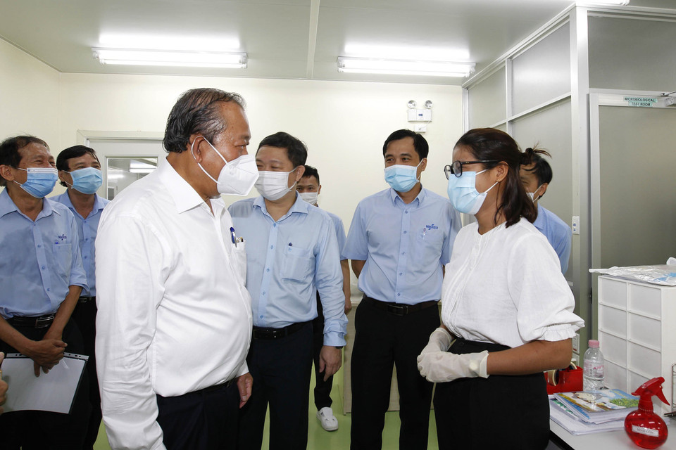 Phó Thủ tướng thường trực Chính phủ Trương Hòa Bình thăm hỏi công nhân tham gia phòng, chống dịch bệnh tại Công ty trách nhiệm hữu hạn Nikkiso, nơi có 1.650 lao động, chuyên sản xuất các bộ dây chuyền máu sử dụng cho máy lọc thận. (Ảnh: Thanh Vũ/TTXVN)