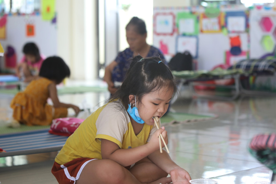 Các cháu nhỏ có khẩu phần ăn ngon hơn những ngày bình thường trong khu cách ly trường Mầm non xã Việt Tiến, huyện Việt Yên. (Ảnh: Danh Lam/TTXVN) 
