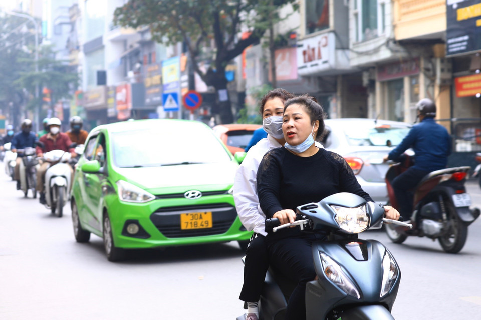  Người dân đeo khẩu trang không đúng cách khi tham gia giao thông trên phố Khâm Thiên (ảnh chụp sáng 10/12/2021). (Ảnh: Hoàng Hiếu/TTXVN)