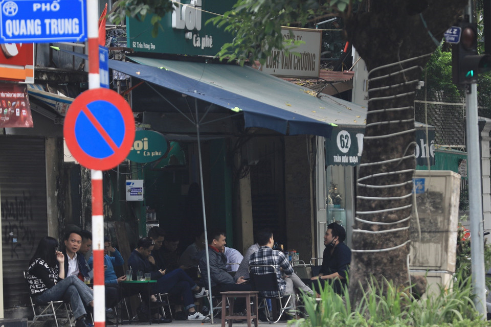 Một quán càphê trên phố Trần Hưng Đạo kinh doanh lấn chiếm vỉa hè, để khách ngồi không đảm bảo khoảng cách phòng dịch. (Ảnh: Hoàng Hiếu/TTXVN)