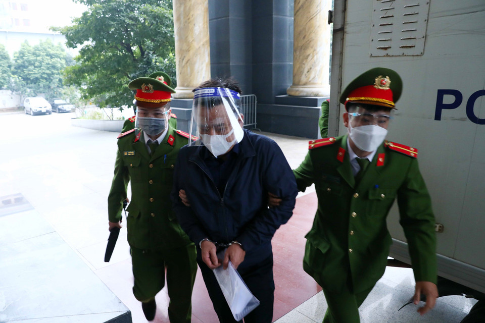 Bị cáo Võ Tiến Hùng (sinh năm 1967, cựu Tổng Giám đốc Công ty TNHH MTV Thoát nước Hà Nội) được lực lượng chức năng dẫn giải đến phiên tòa. (Ảnh: Phạm Kiên/TTXVN