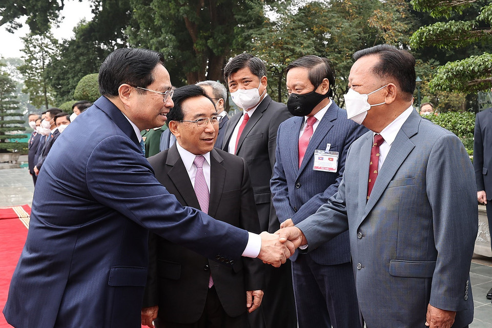 Thủ tướng Lào Phankham Viphavanh giới thiệu với Thủ tướng Phạm Minh Chính thành viên đoàn đại biểu cấp cao Lào. (Ảnh: Dương Giang/TXVN) 