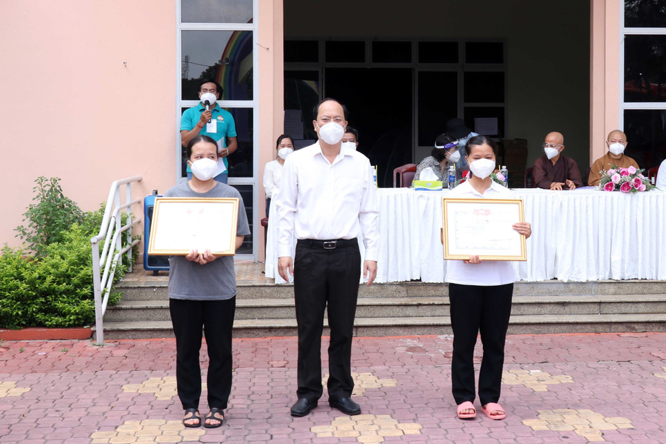 Phó Bí thư Thành ủy Thành phố Hồ Chí Minh Nguyễn Hồ Hải trao giấy biểu dương tri ân các tình nguyện viên đã hoàn thành nhiệm vụ. (Ảnh: Xuân Khu/TTXVN)