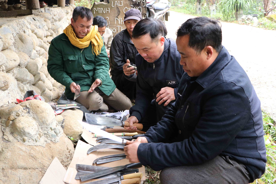 Cánh đàn ông lựa chọn mua dao, rựa dùng cho công việc. (Ảnh: Nguyễn Oanh/TTXVN)