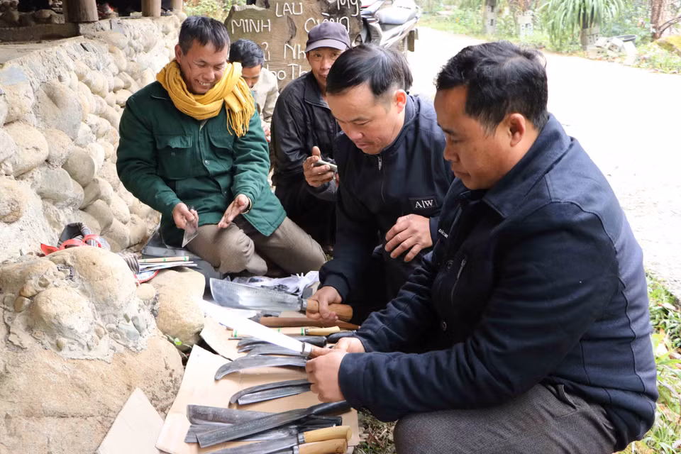 Cánh đàn ông lựa chọn mua dao, rựa dùng cho công việc. (Ảnh: Nguyễn Oanh/TTXVN)