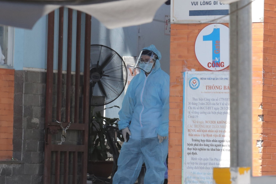 Nhân viên Bệnh viện quận Tân Phú túc trực kiểm soát người ra vào ở khu vực cổng bệnh viện. (Ảnh: TTXVN phát)