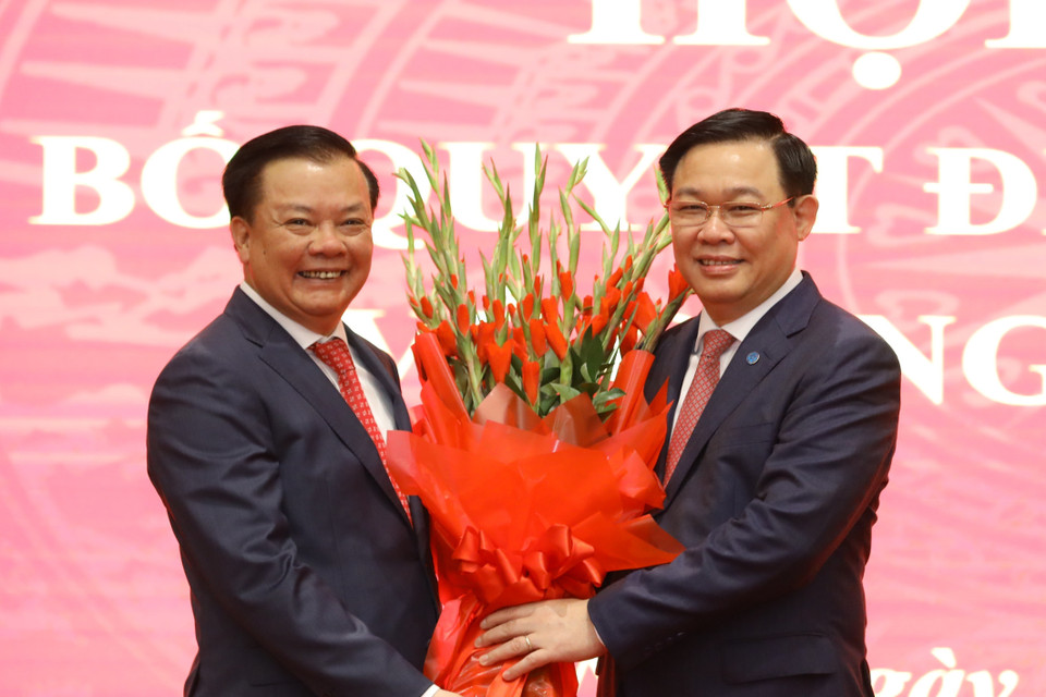 Chủ tịch Quốc hội Vương Đình Huệ tặng hoa chúc mừng Bí thư Thành ủy Hà Nội Đinh Tiến Dũng. (Ảnh: Văn Điệp/TTXVN)