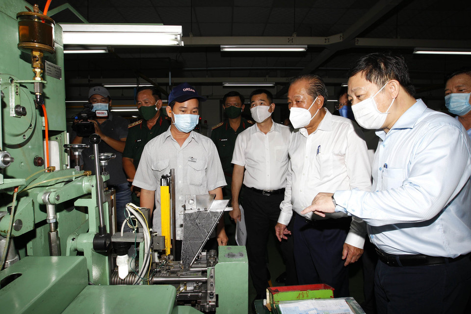 Phó Thủ tướng thường trực Chính phủ Trương Hòa Bình thăm hỏi công nhân tham gia phòng, chống dịch bệnh tại Công ty trách nhiệm hữu hạn Kim may Organ, nơi có khoảng 1.250 lao động, chuyên sản xuất các loại kim may. (Ảnh: Thanh Vũ/TTXVN)
