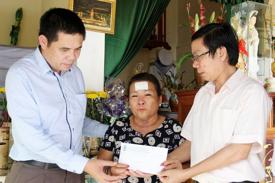 Đại diện Liên đoàn Lao động tỉnh Quảng Trị và Quỹ từ thiện xã hội Tấm lòng Vàng (Báo Lao động) trao tiền hỗ trợ cho bà Nguyễn Thị Hằng, trú tại thành phố Đông Hà, tỉnh Quảng Trị, là mẹ liệt sĩ Hoàng Ánh Đông hy sinh trong cuộc chiến đấu bảo vệ chủ quyền biển đảo Tổ quốc ở Gạc Ma năm 1988. (Ảnh: Hồ Cầu/TTXVN)