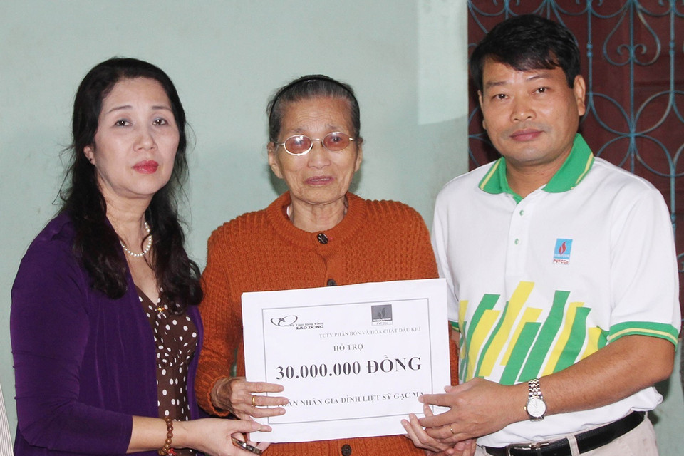 Đại diện Liên đoàn Lao động tỉnh Quảng Trị và Quỹ từ thiện xã hội Tấm lòng Vàng (Báo Lao động) trao số tiền hỗ trợ cho bà Trần Thị Giỏ, trú tại thành phố Đông Hà, là mẹ của liệt sỹ Tống Sỹ Bái hy sinh trong trận chiến đấu bảo vệ chủ quyền biển đảo Tổ quốc ở Gạc Ma năm 1988. (Ảnh: Hồ Cầu/TTXVN)