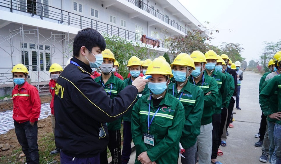 Công nhân, cán bộ thi công đều được kiểm tra thân nhiệt, xét nghiệm trước khi vào công trường và được yêu cầu tuân thủ nghiêm quy định phòng chống dịch. (Ảnh: TTXVN phát)