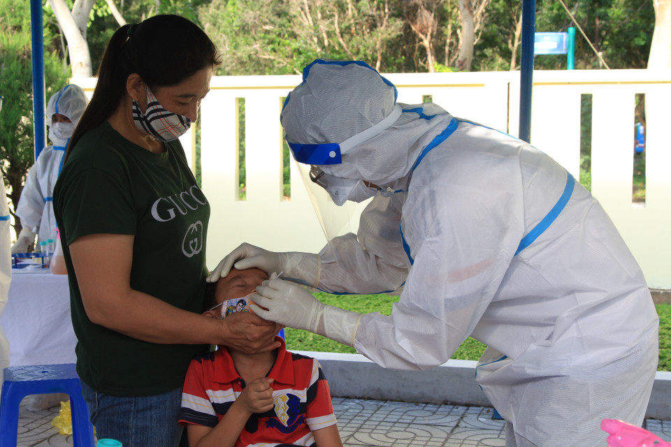 Nhân viên y tế lấy mẫu xét nghiệm sàng lọc virus SARS-CoV-2 cho người dân tại Trung tâm Y tế Quân dân Y Côn Đảo. (Ảnh: Huỳnh Ngọc Sơn/TTXVN)