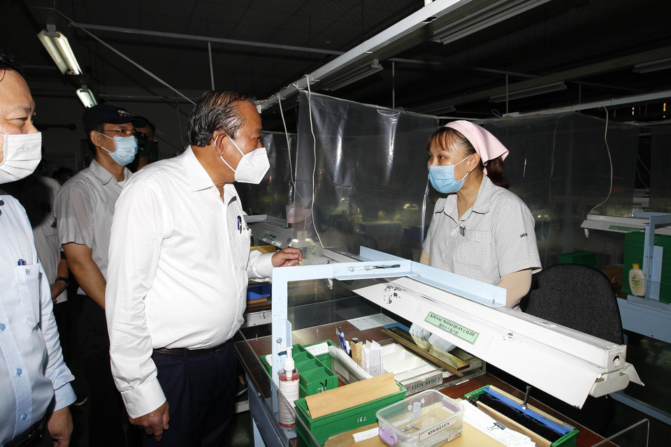 Phó Thủ tướng thường trực Chính phủ Trương Hòa Bình thăm hỏi công nhân tham gia phòng, chống dịch bệnh tại Công ty trách nhiệm hữu hạn Kim may Organ, nơi có khoảng 1.250 lao động, chuyên sản xuất các loại kim may. (Ảnh: Thanh Vũ/TTXVN)