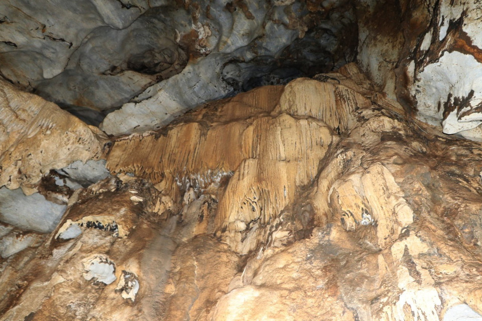 Những rèm nhũ đá có màu sắc vàng óng trên vách khoang trong hang động Hắt Chuông. (Ảnh: Xuân Tiến/TTXVN)